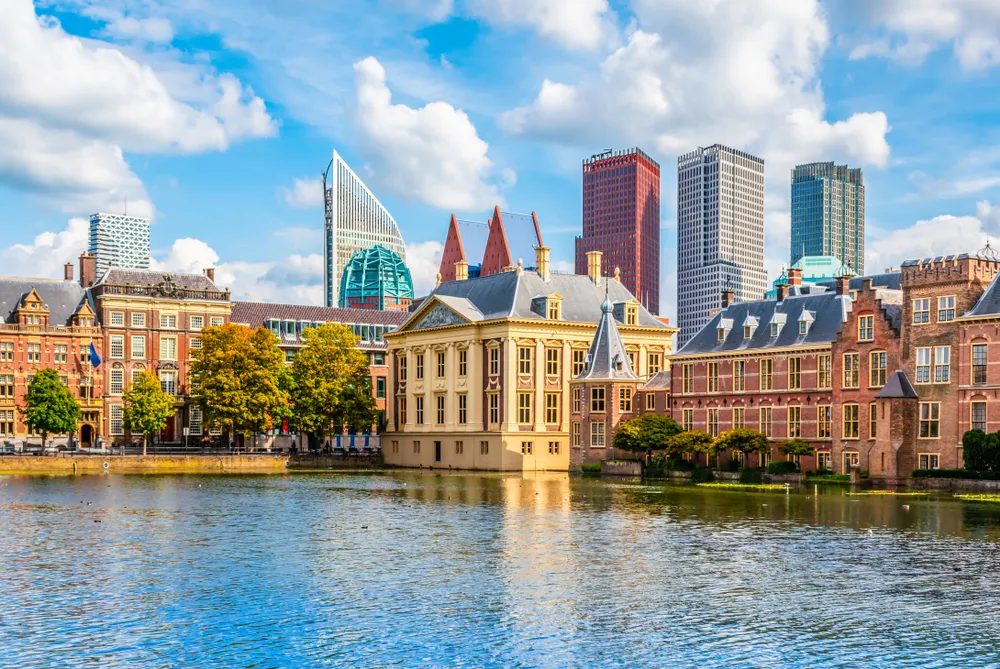 Panorama van het Haagse regeringsgebied met het Binnenhof en moderne overheidsgebouwen op de achtergrond, gezien vanaf het water.