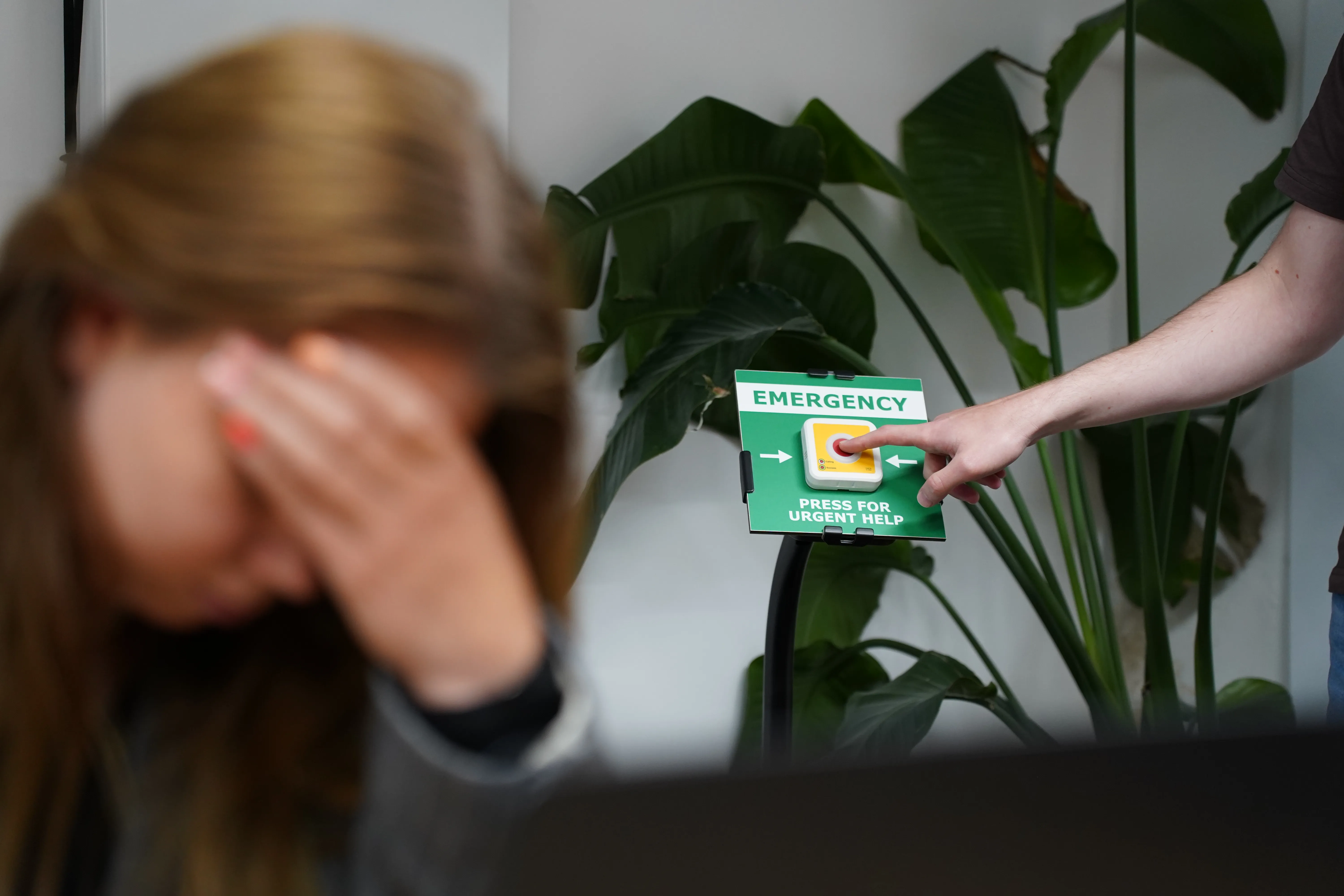 Vrouw onwel op werk en man drukt op BHV Knop