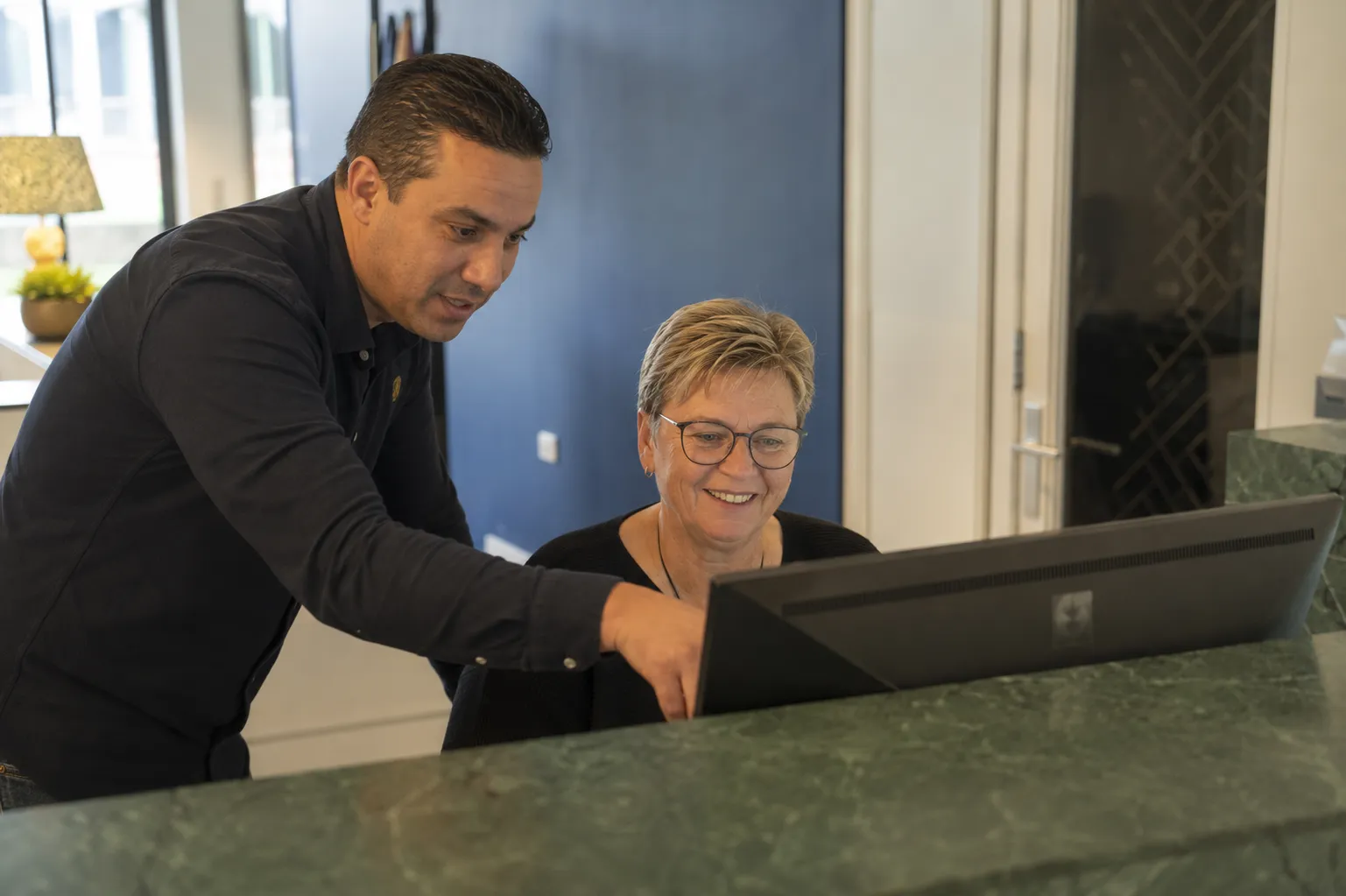 Man legt dingen uit aan de receptioniste 